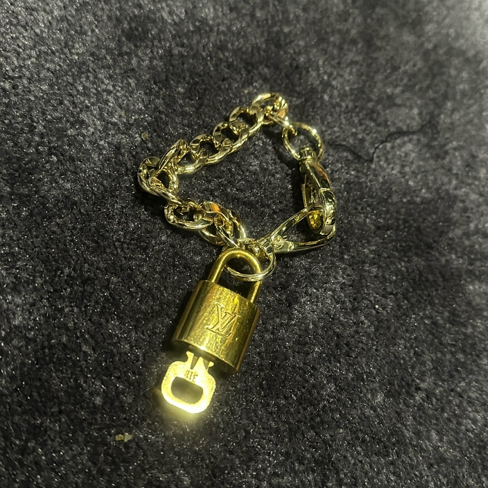 #311…Unisex Branded Luis Vuitton lock with unbranded 8” bracelet chain.